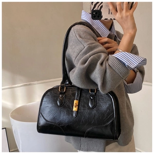 Detailansicht der schwarzen Wildleder-Boston-Tasche mit goldener Schnalle und Trageriemen