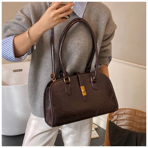 Detail der dunkelbraunen Vintage Boston Tasche mit goldenem Drehverschluss und langem Griff