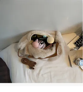 Intérieur spacieux du sac bandoulière en peluche contenant parapluie et bouteille