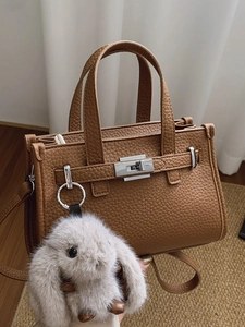 Brown lychee leather handbag with silver twist lock and plush rabbit charm