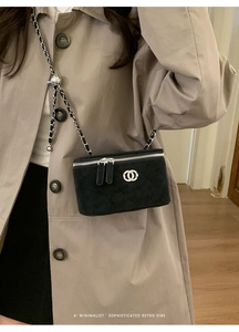 Detail of black quilted leather mini box bag with chain strap and silver ball adjuster