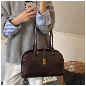 Detailansicht der dunkelbraunen Vintage Wildleder-Boston-Tasche mit goldenem Drehverschluss