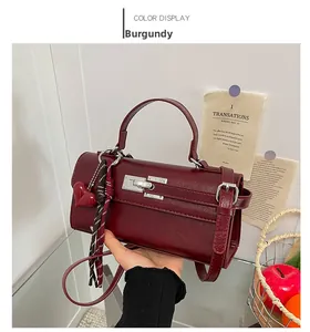 Détail du sac à main bordeaux avec boucle argentée et breloque coeur à franges
