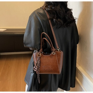 Detailed view of dark brown leather crossbody bag with MKXQ COEOR embossed logo