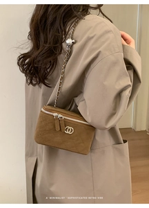 Chic brown quilted crossbody bag with golden chain strap on model in neutral outfit