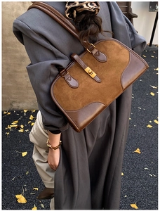 Detail der Vintage-Boston-Tasche aus Wildleder mit Ledernaht und Goldschnalle im Herbststil