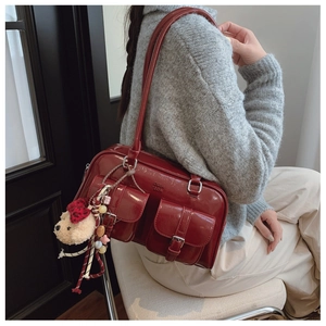 Détail du sac sous le bras bordeaux avec doubles poches avant et pendentif ours mignon