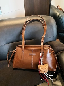 Retro brown faux leather shoulder bag with adjustable straps and a plush bear pendant