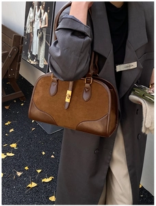 Details der braunen Wildleder-Boston-Tasche mit Goldschnalle, präsentiert im Herbst-Look