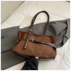 Détail du sac cabas en suédine marron avec sangle décorative et œillets métalliques