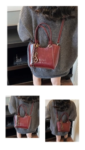 Détails du sac seau bordeaux avec logo KXQ OEOR embossé et pompon à franges nouées