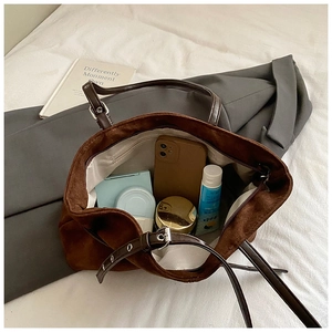 Détail de l'intérieur spacieux avec poche zippée dans le cabas en daim marron foncé