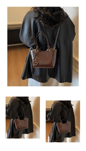 Détail du sac seau en cuir marron rétro montrant le logo et l'accessoire de noeud chic