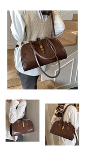 Detail der braunen Suede-Boston-Tasche mit goldenem Drehverschluss und Lederverarbeitung