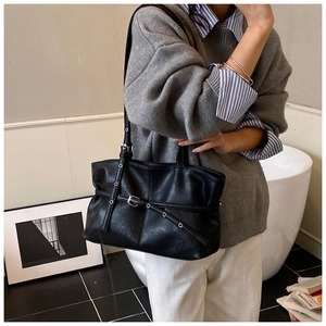 Détail du sac cabas noir mat avec œillets métalliques argentés et sangles décoratives
