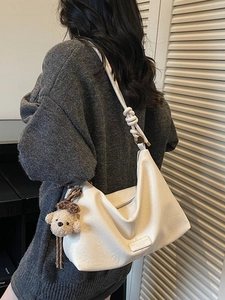 White soft PU leather crescent shoulder bag with woven knot strap and plush dog charm