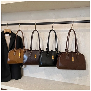 Details von vier Retro-Boston-Taschen aus Wildleder in Braun und Schwarz mit Golddekor