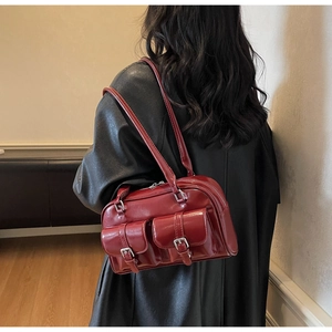 Dark red retro shoulder bag with double front pockets on a model with a black coat