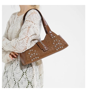 Detail of brown leopard print leather shoulder bag with silver studs on model