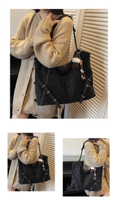 Detail view of large black tote bag featuring white contrast stitching and silver buckles