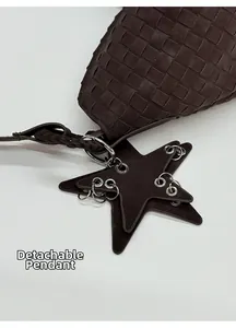 Detail of dark brown woven leather tote bag with a removable star-shaped pendant