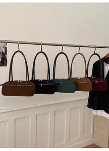 Detailed display of vintage matte baguette bags in five colors hanging on a metal rack