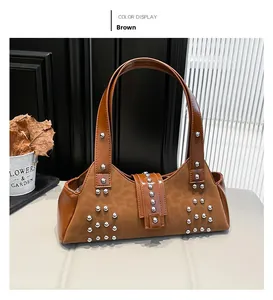 Detail shot of brown faux suede handbag featuring silver rivets and biker-style hardware