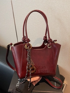 Burgundy patent leather crossbody handbag with KXQ embossed letters and rope charm