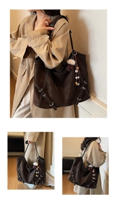 Detail view of large dark brown leather tote bag with silver hardware and charm pendant