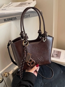 Dark brown faux leather crossbody bag with letter embossing and knot handle detail