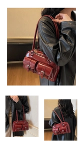 Detail of dark red vintage underarm bag with double front flap pockets and buckles