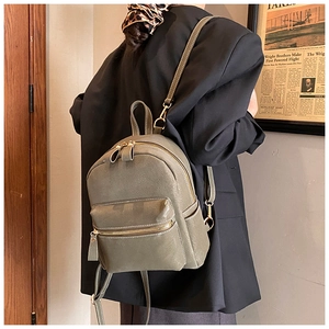 Detailed back view of mini olive green suede backpack with stylish white contrast stitching