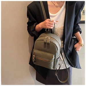 Detail of olive green faux suede mini backpack with golden zippers and slim straps