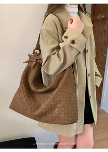 Detail of woven leather hobo bag in dark brown with a unique star charm on the strap