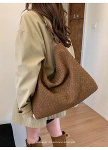 Detailed close-up of brown woven leather hobo bag texture and large capacity design