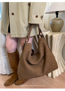 Detailed close-up of brown leather intrecciato woven texture and metallic ring hardware