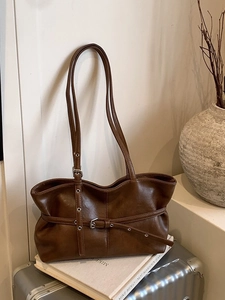 Sac cabas vintage en cuir PU marron foncé avec lanières à œillets sur une valise