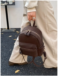 Detail of dark brown mini faux leather backpack with contrast stitching and gold hardware