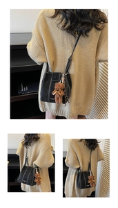 Détail du sac seau noir avec surpiqûres contrastées et breloque d'ours en peluche