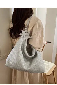 Detail view of woven leather hobo tote bag featuring star charms and large capacity