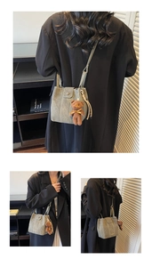 Détail du sac seau en cuir mat gris-vert avec breloque ours en peluche et rabat aimanté