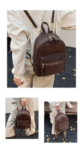 Close-up of vintage brown suede mini backpack with white contrast stitching and gold zippers
