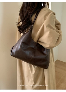 Model view of large brown retro leather tote bag showing drape and capacity on shoulder