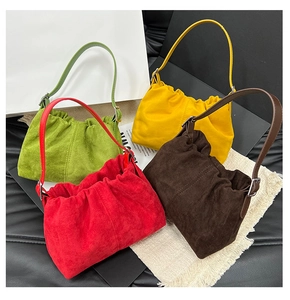 Detail of four colorful ruched bucket bags in suede-like texture with metallic buckles