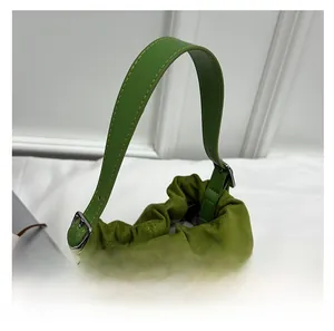 Detail of green bucket bag with adjustable strap and textured matte suede fabric