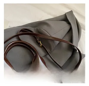 Detail of deep brown glossy leather bucket bag showing adjustable shoulder strap hardware