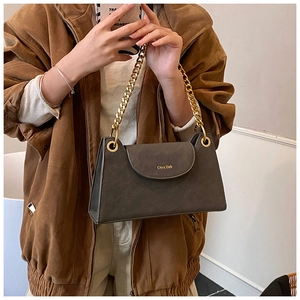 Detail of dark grey leather handbag with large gold eyelets and chunky chain strap