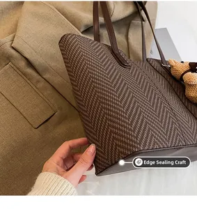 Detail of herringbone weave tote bag featuring premium edge paint and bear charm