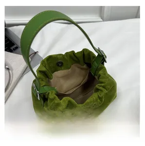 Detail showing green suede bucket bag interior with magnetic clasp and inner pocket