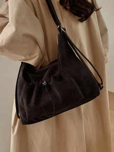 Large vintage suede tote bag in dark brown worn by model in a stylish trench coat